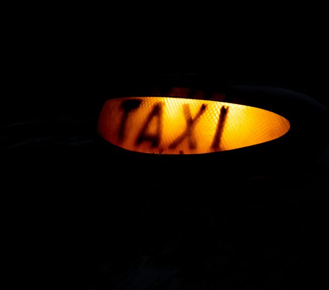 Close-up of a glowing taxi sign in the dark